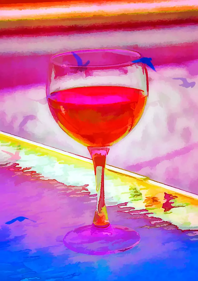 abstract of wine glass holding rosè wine on a glass table top with profiles of birds flying out of the glass